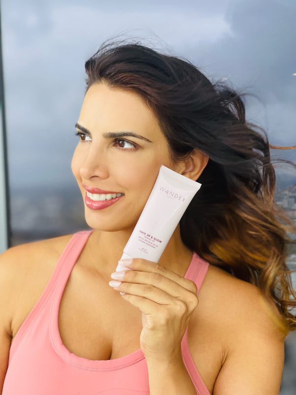 Model in pink top holding a pack up & glow product in her hand